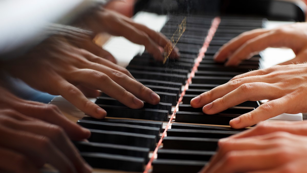 fyrhändigt pianospelande